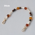 Dettaglio della catena di perle acriliche da 36cm con chiusure dorate in ambra e crema - 36CM / Ambra
