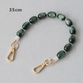 Detail view of 35cm dark green cat eye bead bag chain with gold lobster clasps - Green with Gold Beads