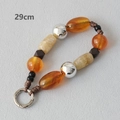 Detail view of a 29cm acrylic bead chain with amber resin and polished silver metal rings - 29cm