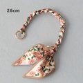 Detail view of 26cm floral silk scarf bag handle strap with a bow and gold metal rings - Beige And Pink Floral