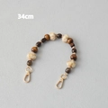 Detail view of 34cm fashion strap with dark wood beads and soft beige faux fur pom poms - Style 3 / 34cm