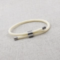 Detailed macro view of cream braided rope bracelet with adjustable silver metal slide buckle - Style A (Round) / Off-white