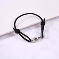 Close-up of adjustable black woven rope bracelet with polished silver metal handcuffs - Black