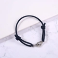 Close-up of adjustable navy braided rope bracelet with a silver stainless steel handcuff clasp - Navy Blue