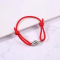 Detail of red braided rope bracelet with adjustable knots and silver handcuff charm - Red