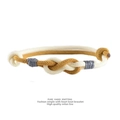 Detail of hand-knitted Milan line couple bracelet featuring a minimalist heart knot design - Cream White + Turmeric