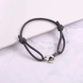 Macro shot of grey braided rope bracelet with polished silver metal handcuff clasp - Dark Gray