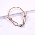 Detail view of khaki woven rope bracelet with adjustable knots and stainless steel handcuffs - Khaki