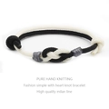 Close-up of handmade dual-tone woven heart knot bracelet with high quality milan line - Cream White & Black