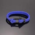 Makro-Detail des blauen geflochtenen Armbands mit schwarzem strukturiertem Hufeisenverschluss - Saphirblau