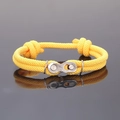 Gros plan d'un bracelet en corde tressée jaune avec une boucle de chaîne de vélo en métal - Jaune
