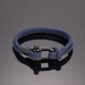 Detail eines dunkelblauen geflochtenen Armbands mit schwarzer U-förmiger Metallschließe - Marineblau