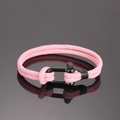 Detail eines rosa geflochtenen Segeltau-Armbands mit schwarzem U-förmigem Schäkelverschluss - Rosa