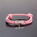 Détail macro du bracelet rose tissé avec maillon de chaîne en acier inoxydable - Rose