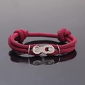 Gros plan d'un bracelet tressé bordeaux avec une boucle en forme de chaîne de vélo argent - Bordeaux