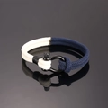 Detail van blauw-wit gevlochten touwarmband met een zwarte metalen U-vormige sluiting - Beige en Marineblauw (D-sluiting Stijl)