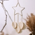 Detailed macro shot of handmade macrame star wall hanging with woven cotton feathers - Star With Leaves