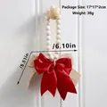Detail view of rustic wall decor featuring wooden beads and a large red ribbon bow - Large Red Satin Bow (ms9769)