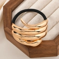 Irregular gold metal hair tie with black high-elastic rope on a beige jewelry tray - Gold