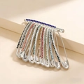 Macro shot of silver safety pin brooch with hanging colorful rainbow rhinestones - Silver/AB Zirconia