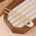 Detail of a gold U-shaped metal hair pin with a white marble-textured decorative inlay - Semicircle Resin White