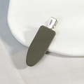 Vue détaillée d'une pince à cheveux vert olive mat sur un plateau géométrique - Vert Foncé
