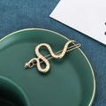 Eleganter goldener Schlangen-Haarclip mit Metallschuppen auf einer grünen Keramikplatte - Gold (B9326)