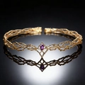 Macro view of golden vine crown with purple teardrop gemstone and reflection - Gold Purple Rhinestone