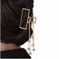 Dettaglio della molletta dorata con lunghe nappe e perline marroni su uno chignon basso - Perline a Nappa Rettangolari