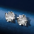 Orecchini a camelia in argento con petali metallici su un supporto blu scuro - Argento