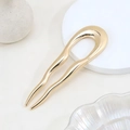 Minimalist U-shaped wavy hair fork in polished gold finish on a luxury display stand - Gold