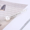 Dettaglio di un fermaglio per capelli argento con una perla tonda e strass scintillanti - Stile con Perle Grandi