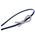 Dettaglio del cerchietto in raso blu navy con fiocco di strass su sfondo bianco - papillon