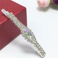 Primer plano de horquilla de strass con cristal holográfico sobre una caja de regalo roja - Color AB