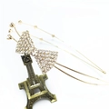 Detail of a double-layered gold headband featuring a sparkling rhinestone bow design - Gold