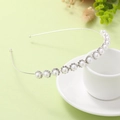 Diadema de perlas plateadas con strass apoyada en una taza de café, estilo elegante - Perla Plateada
