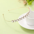 Primer plano detallado de la diadema dorada con flores de perlas sobre taza blanca - Dorado