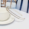 Serre-tête doré élégant à double couche avec strass colorés posé sur une tasse - Strass AB Or