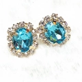 Detalle de pendientes de gema ovalada azul claro con halo de cristales y baño de oro - Estilo Verde (A3520)