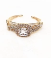 Macro shot of gold-plated multi-wire cuff bracelet featuring large cushion-cut crystal and rhinestones - Square Decorative Style / Gold