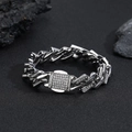 Close-up of silver Cuban link bracelet with sparkling rhinestones on textured black stone - Silver Color Bracelet