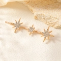 Detailed close-up of golden hair clip featuring sparkling rhinestones on eight-point stars - Triple Star Row Clip / Gold