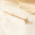 Detailed close-up of a gold star hair clip with rhinestones on a natural stone background - Small Sun Clip / Gold