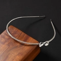 Dettaglio del cerchietto d'argento con cristalli brillanti e fiocco elegante - Vetro Bianco Argento