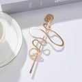 Minimalistische goldene Haarnadel aus Metall mit gewundenem Design auf weißem Tisch - Gold