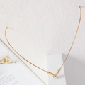 Macro detail of elegant golden V-shaped choker with small beads and sparkling center zircon - Round Bead With Diamond Style (B9207)