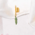 Detailed shot of a vintage gold spiral hair ring with a green enamel feather pendant - Feather (F1502)