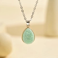 Macro d'un pendentif goutte en résine vert clair avec bordure dorée et chaîne argent - Argent Vert Clair