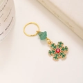 Weihnachts-Schneeflocken-Anhänger mit grünem Stein und rotem Strass auf goldenem Ring - Schneeflocke