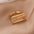 Minimalistischer rechteckiger Goldring mit geometrischem Design auf Champagner-Satin - Gold